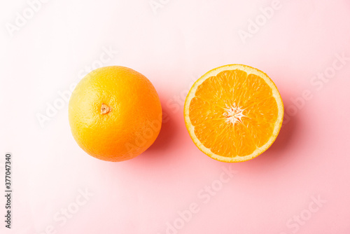 Top view of Fresh half orange fruit slice and full orange in the studio shot isolated on pink background  Healthy food concept