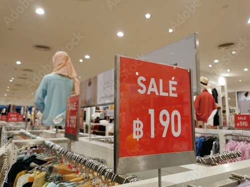 Red sale sign discount in clothing modern shopping mall or department store. Retail shop promotional event, product discount, business marketing advertising, low price concept. Tag of 190 Thai Bahts