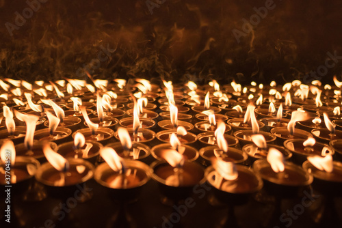 A ground of burning candles lighting up with shallow depth of field at buddhist temple in Kathmandu,Nepal.