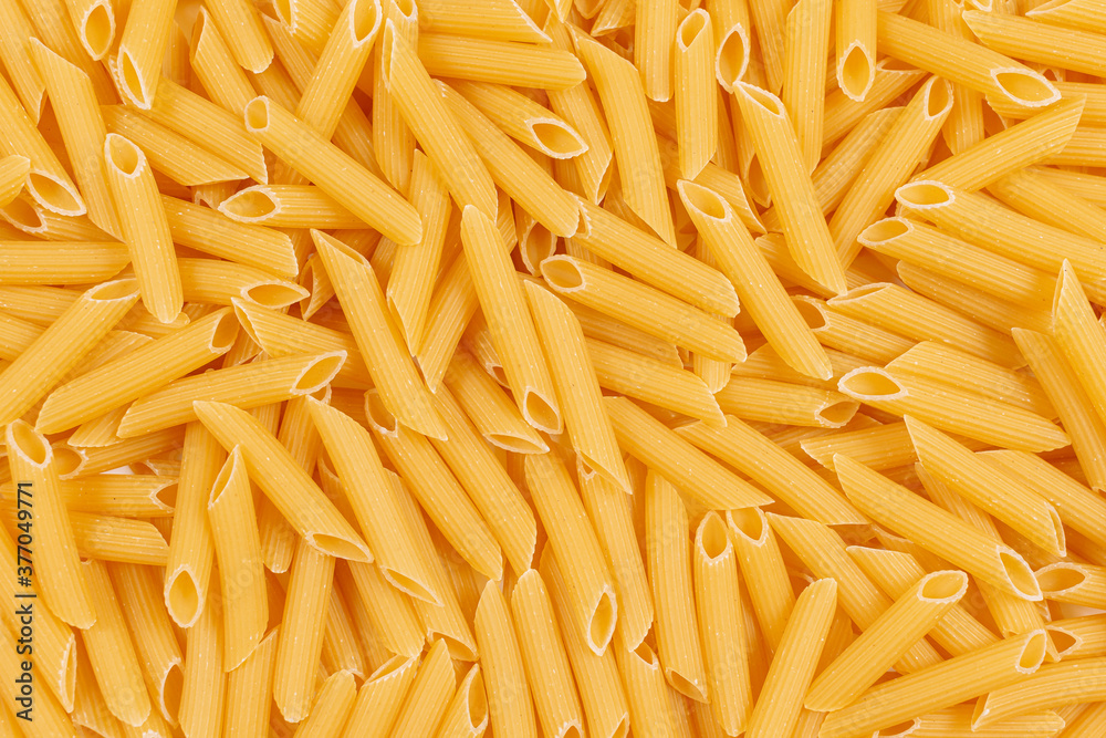 Raw penne pasta background. Close up of uncooked penne pasta. Top view Raw penne pasta background. Close up of uncooked penne pasta. Top view