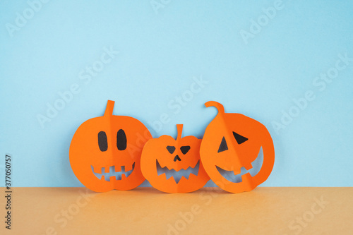 Funny Halloween pumpkins made paper on pastel background. Happy halloween holiday concept. Close up, copy space