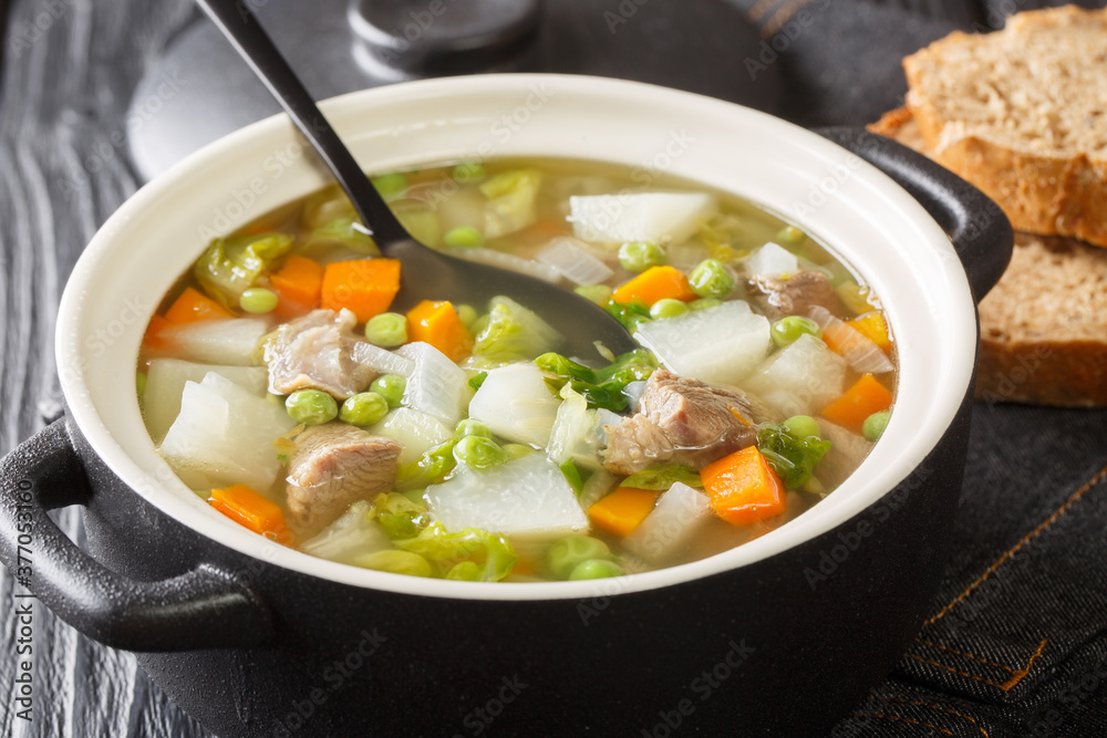 Hairst bree Lamb and summer vegetable soup close-up in a pot on the table. Horizontal