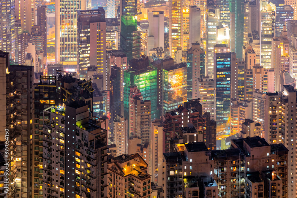 Close up modern high rise building view from the Victoria peak at night time in Hong Kong.