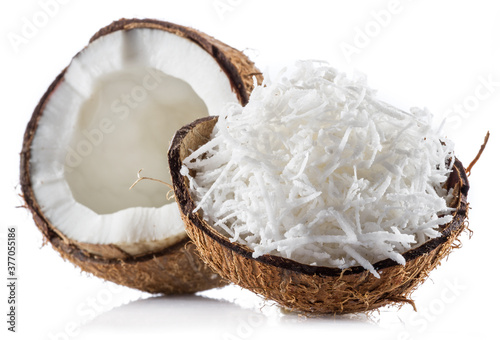 Coconut fruit and shredded coconut flakes in the piece of shell isolated on white background.