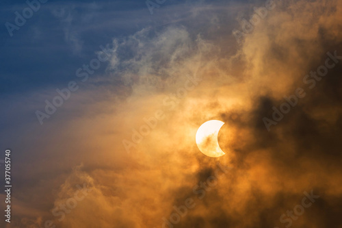 The Moon covering the Sun in a partial eclipse with dramatic cloud. Scientific background, astronomical phenomenon