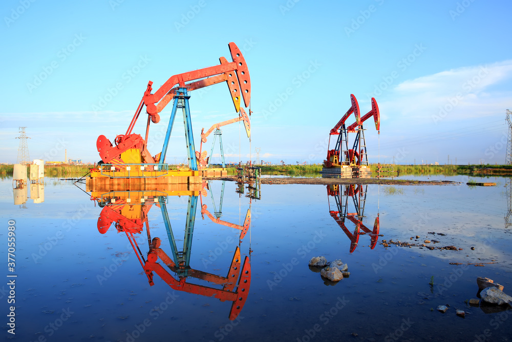 Oil pump under the blue sky, beam pumping unit in the oil field Oil pump under the blue sky, beam pumping unit in the oil field