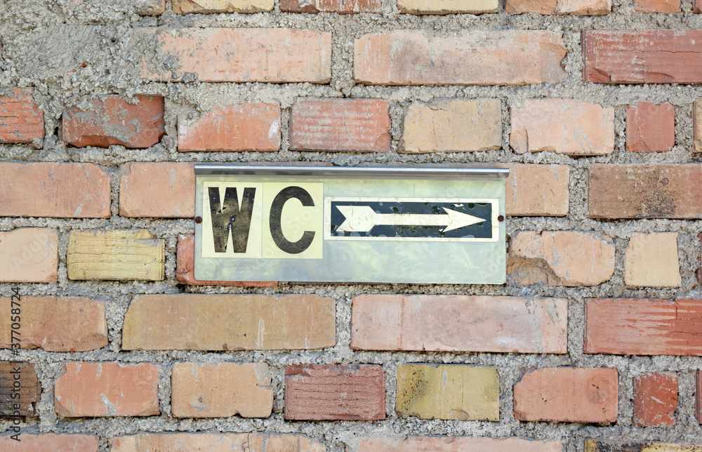 Toilet sign on an old brick wall Toilet sign on an old brick wall