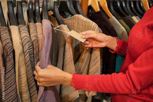 Young travel woman chooses Thai traditional dressing in Village shop, Thailand handmade product.