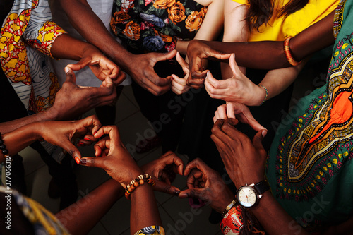 Hands make symbol of heart. Happy group of multinational African, latin american and european people which stay together in circle