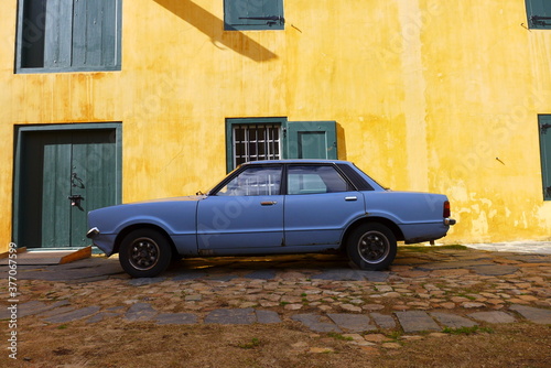 Vintage blue car against yellow wall