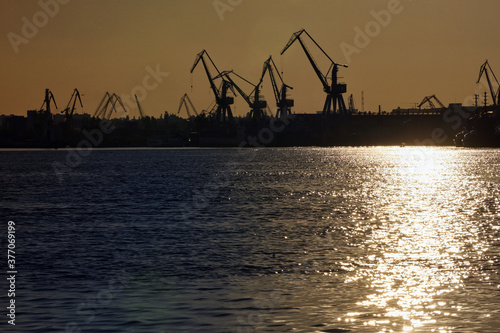 Harbor and Cranes against red sunset background © icarmen13