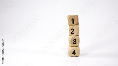 Stack of four wooden dice on white background