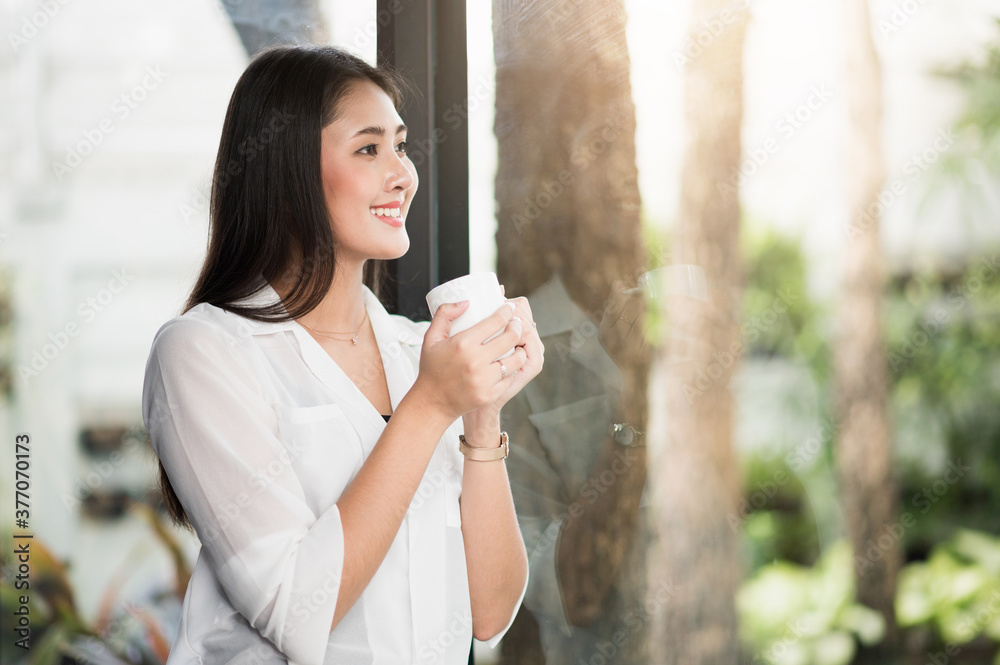 Beautiful asian woman drinking coffee at home in the morning. Smiling charming happy young female stay at home. Beautiful asian woman drinking coffee at home in the morning. Smiling charming happy young female stay at home.