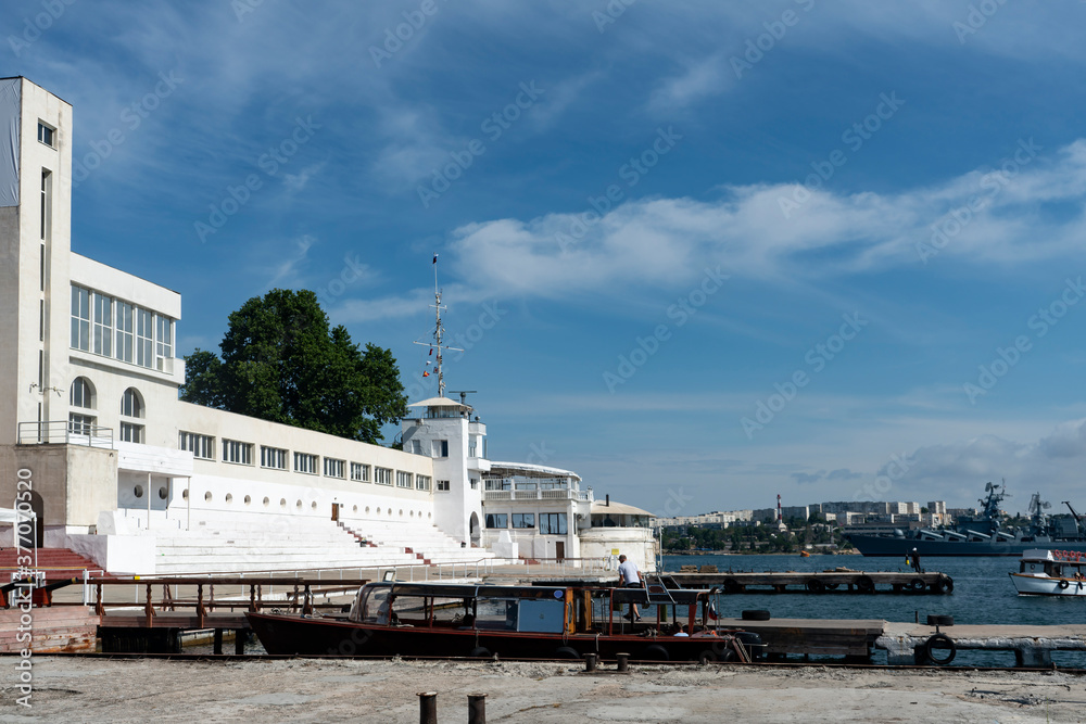 White seaport building with a pier for small ships.