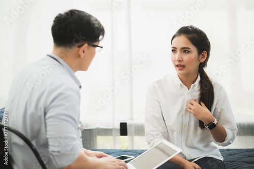 Young handsome asian psychologist doctor using laptop consulting to female patients in therapy session.