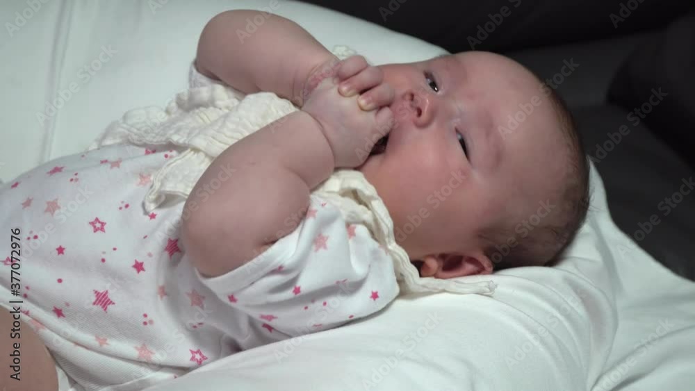 Baby sucking fingers happily while lying on the bed Baby sucking fingers happily while lying on the bed