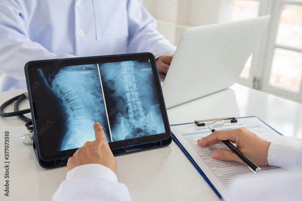 Foto de doctor diagnose spine lumber vertebrae xray image on digital tablet for diagnose