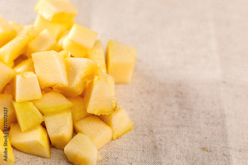 Zucchini or pumpkin cut into cubes piled on linen towel. Close up Zucchini or pumpkin cut into cubes piled on linen towel. Close up