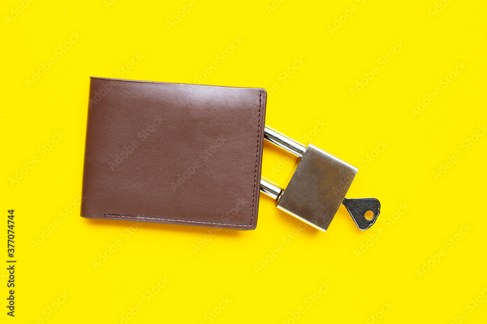 Wallet with padlock and key on yellow background. Wallet with padlock and key on yellow background.