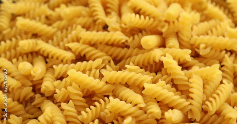 Heap of rotating fusilli pasta on plate closeup