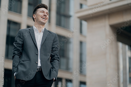 male businessman smiling enjoying life, background business center