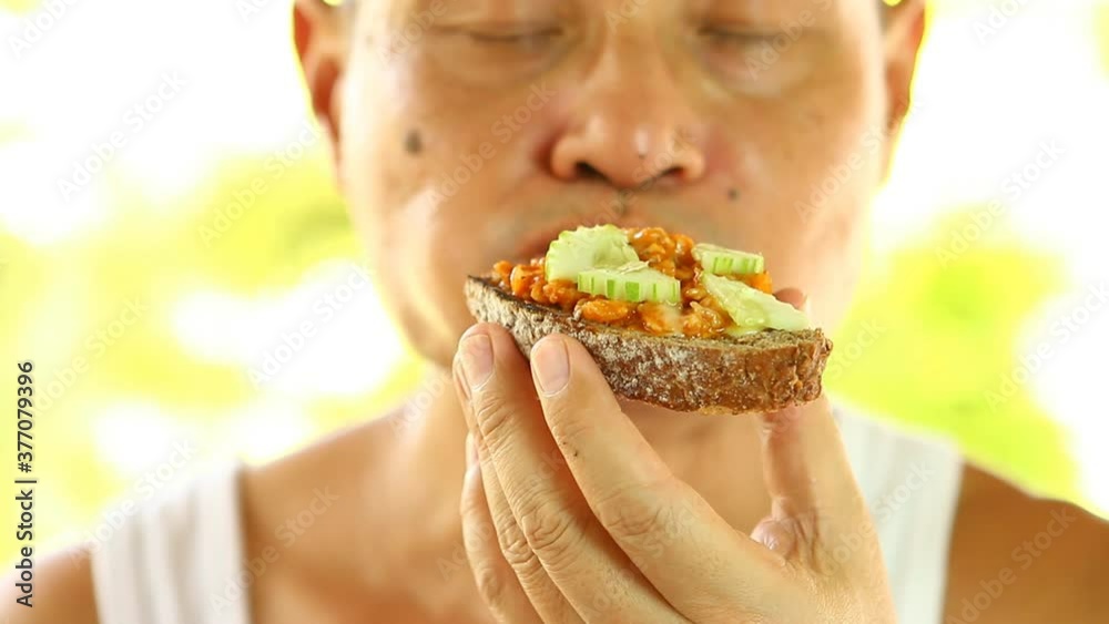 Thai man eating bread , out door Chiangmai Thailand Thai man eating bread , out door Chiangmai Thailand