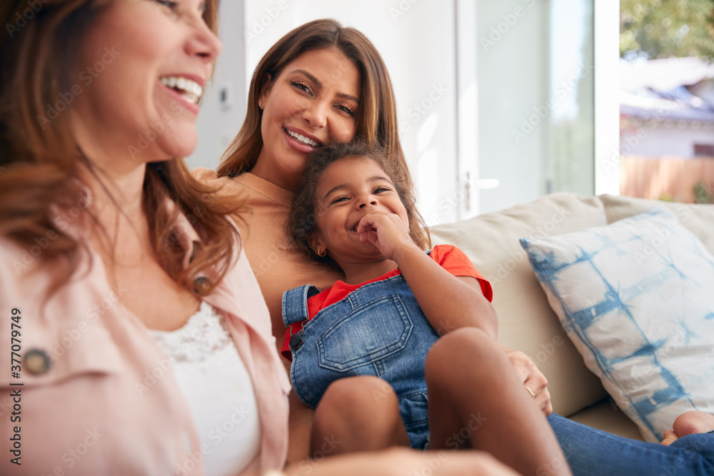 Multi-Generation Female Hispanic Family Relaxing On Sofa At Home 