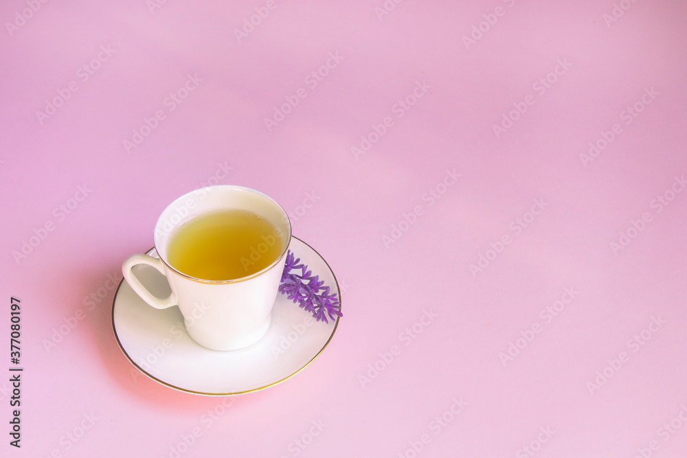 Ceramic Cup of green herbal tea on a pink surface. The view from the top. The concept of the tea party. Copy space. Template for recipes and ingredients. Ceramic Cup of green herbal tea on a pink surface. The view from the top. The concept of the tea party. Copy space. Template for recipes and ingredients.