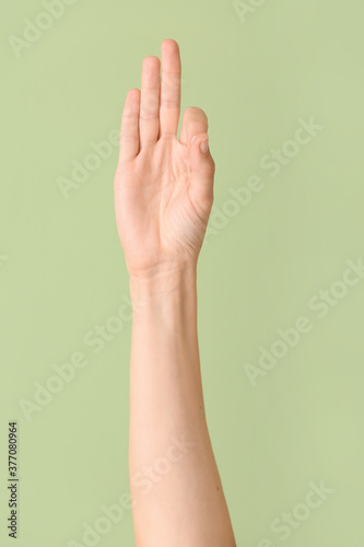 Hand showing letter F on color background. Sign language alphabet