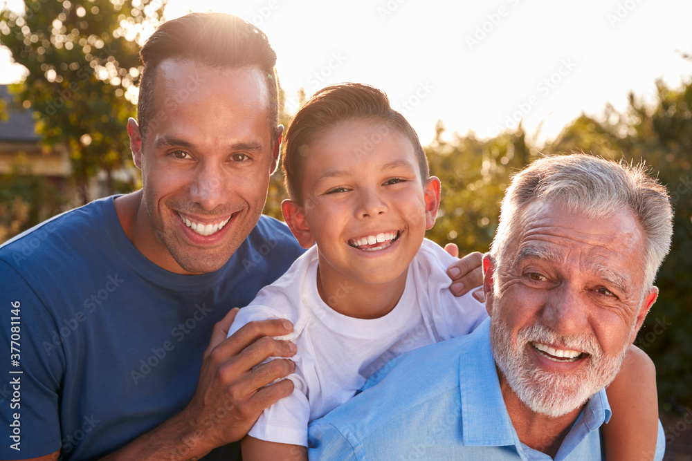 Portrait Of Male Multi-Generation Hispanic Family Relaxing In Garden At Home Together Portrait Of Male Multi-Generation Hispanic Family Relaxing In Garden At Home Together