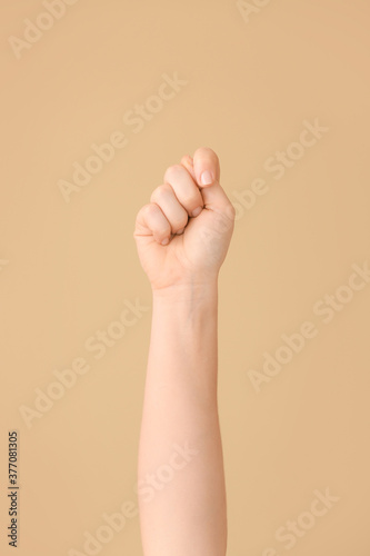 Hand showing letter T on color background. Sign language alphabet