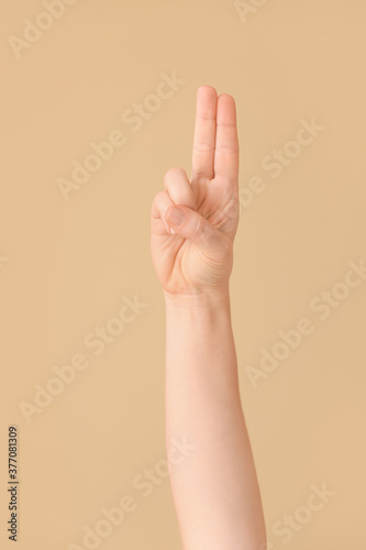 Hand showing letter U on color background. Sign language alphabet