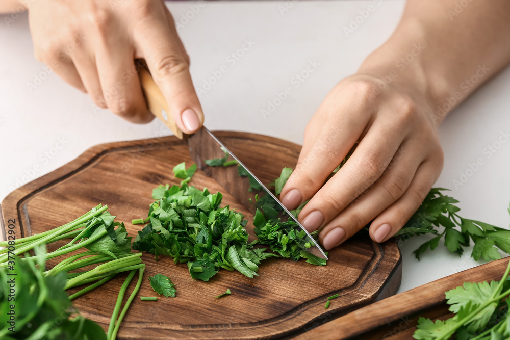 Woman cutting fresh parsley, closeup Woman cutting fresh parsley, closeup