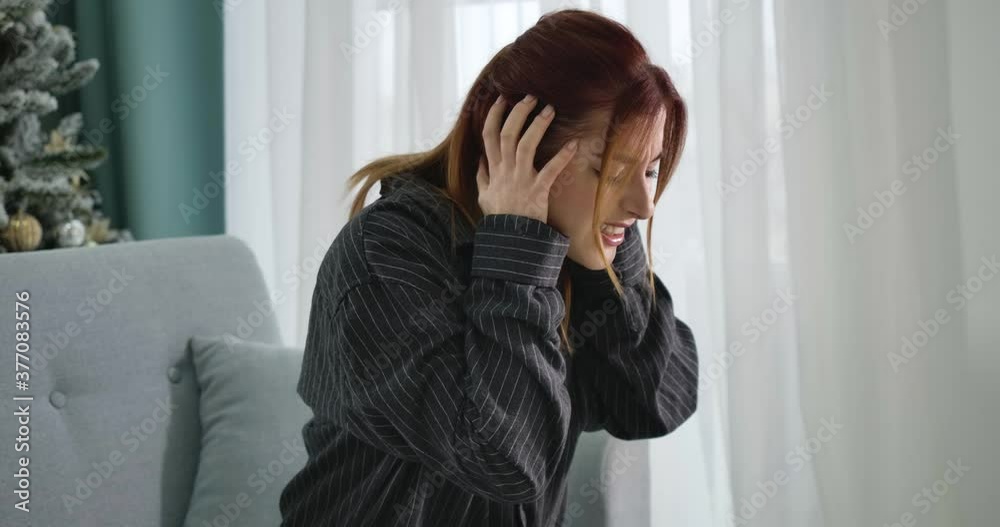Ill young woman suffering from severe migraine at home on New Year's eve. Side view portrait of beautiful Caucasian lady having headache on Christmas. Medical problems. Cinema 4k ProRes HQ. Ill young woman suffering from severe migraine at home on New Year's eve. Side view portrait of beautiful Caucasian lady having headache on Christmas. Medical problems. Cinema 4k ProRes HQ.
