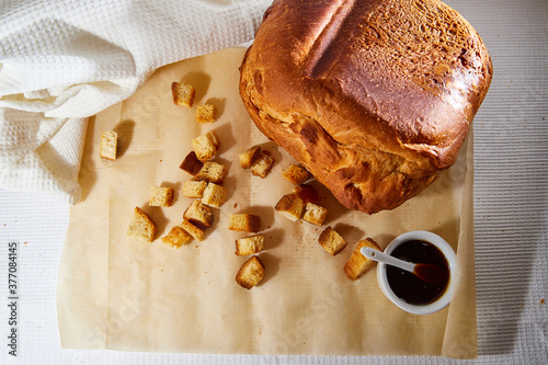 Square toasted pieces of homemade delicious rusk, hardtack, Dryasdust, zwieback, bread and Liquid honey in a white plate on a white tablecloth. photo