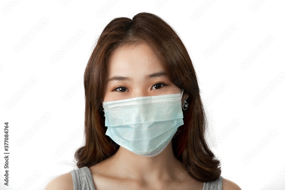Young beautiful Asian woman wearing protective face mask, posing on white background. During quarantine of coronavirus pandemic and COVID-19 pandemic infectious disease outbreak. healthcare concept. Young beautiful Asian woman wearing protective face mask, posing on white background. During quarantine of coronavirus pandemic and COVID-19 pandemic infectious disease outbreak. healthcare concept.