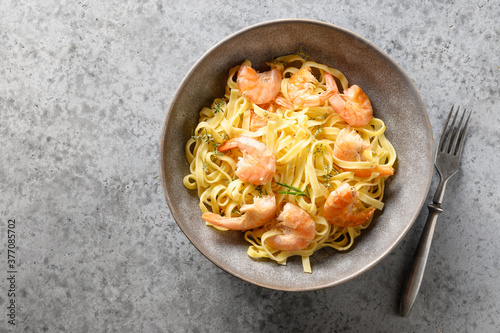 Italian pasta fettuccine with seafood, shrimps on gray table. View from above.