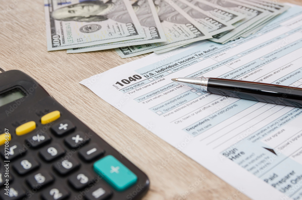 Time for Taxes, Federal Form 1040 with Pen, Dollars and Calculator, Office Desk. Paperwork. Time for Taxes, Federal Form 1040 with Pen, Dollars and Calculator, Office Desk. Paperwork.