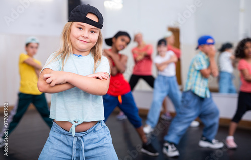 Cute girl performing hip hop at group dance class  modern dance school for kids