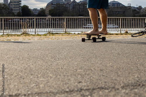 barefoot man skateboarding on the street