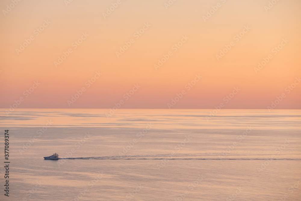 Obraz premium Yacht floating in ocean. Nature landscape. Panoramic view of sea sunset. Cloudless sky and golden hour, copy space