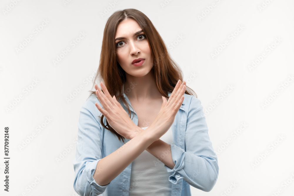 Photo of Serious girl gesturing stop, finish, symbol of rejection, not allow violence, body language Photo of Serious girl gesturing stop, finish, symbol of rejection, not allow violence, body language