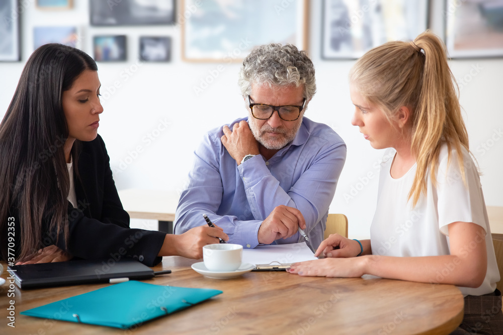 Family legal advisor explaining document details to mature father and adult daughter. Medium shot. Expertise or paperwork concept Family legal advisor explaining document details to mature father and adult daughter. Medium shot. Expertise or paperwork concept