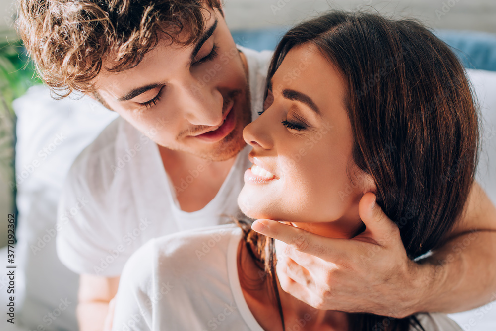 Young man looking at girlfriend and touching neck and face Young man looking at girlfriend and touching neck and face