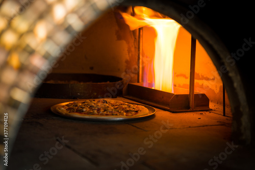 Baking a pizza in wood fired oven, Traditional pizza