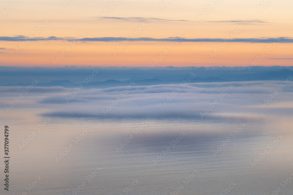 Seascape with low fog clouds over sea water in early morning  sunrise. Beautiful nature background