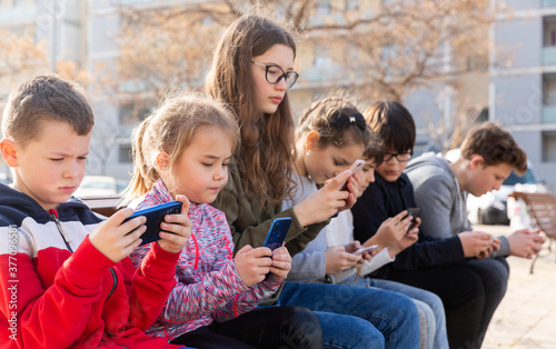 Children communicate via messengers on phones. High quality photo © JackF