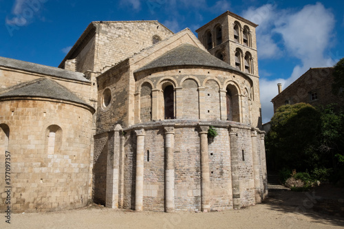 The ancient stone architecture and the blooming garden of the old  catholic Caunes Minervois abbey located in the most beautiful medieval village of France photo