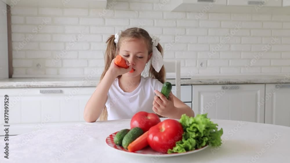 the child eats vegetables with joy and pleasure. a little girl dines in the kitchen. the concept of healthy eating the child eats vegetables with joy and pleasure. a little girl dines in the kitchen. the concept of healthy eating