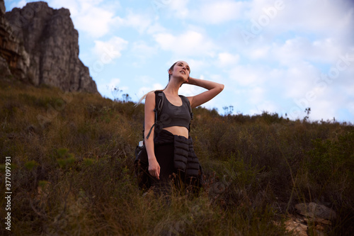 Young woman on a hike stood on side of a mountain © Southworks